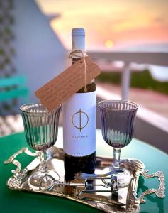 a bottle of wine and two glasses on a tray at Beachfront Luxury Studio with Panoramic Sea View in Ialysos +11 photos