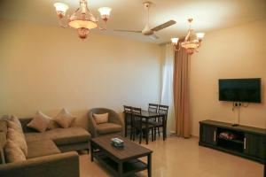 a living room with a couch and a tv at Al Sahwa Residency in Ţāqah