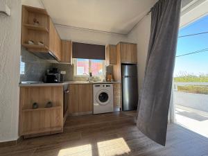 a kitchen with a washer and dryer in it at Beachfront Luxury Studio with Panoramic Sea View in Ialysos