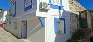 two pictures of a building with blue doors and a street at Oikos Filon in Palaiókastron