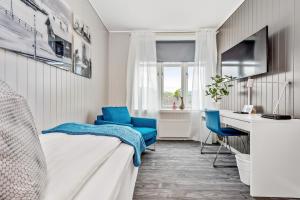 a bedroom with a bed and a desk and chairs at Mogården in Orkanger