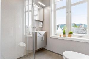 a bathroom with a toilet and a sink and a window at Mogården in Orkanger +27 photos