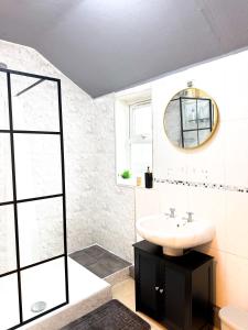 a bathroom with a sink and a mirror at Spacious 3 Bed , Free Parking , Fast WiFi , Long Stays in Kettering +24 photos