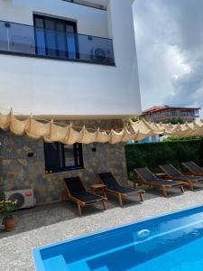 a villa with a swimming pool and lounge chairs at Villa Kociu in Ksamil