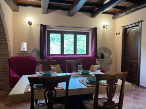 a dining room with a table and chairs and a window at Villa Valle Tassignana in Casperia