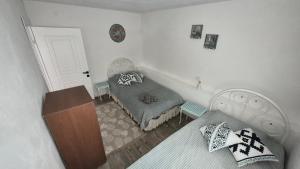 a small bedroom with a bed and a chair at Assos Egedebirnefes Kır Evi in Ayvacık