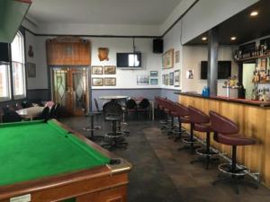 a pool table in a bar with chairs and a pool table at Lords Hotel in Scottsdale