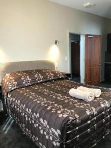 a bedroom with a bed with towels on it at Lords Hotel in Scottsdale