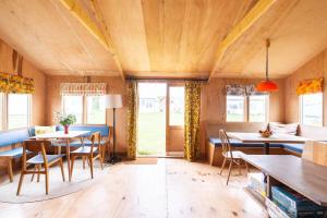 a dining room with tables and chairs and windows at Bacton Beach Cabin in Bacton