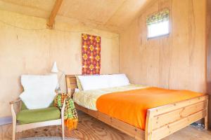 a bedroom with a bed and a chair in it at Bacton Beach Cabin in Bacton