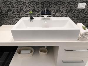 a white bathroom sink with two baskets under it at Souvenir D Italie in Alatri