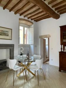 a dining room with a glass table and white chairs at Pinturicchio Luxury Suite in Perugia