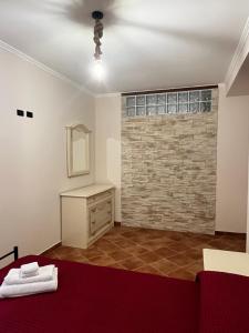 a room with a stone wall and a dresser and a bed at Villa Valle Tassignana in Casperia +19 photos