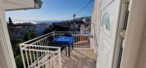 a balcony with a blue table and chairs on it at Apartment Mateo 2 mit Meeresblick und Mateo 1 mit Gartenblick in Selce