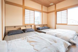 two beds in a room with two windows at umiakari in Naruto