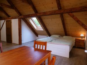 a bedroom with a bed and a table in a attic at Škola Kačerov in Zdobnice