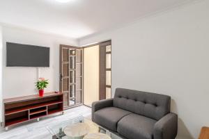 a living room with a couch and a tv at Sintha guest house in Kraaifontein
