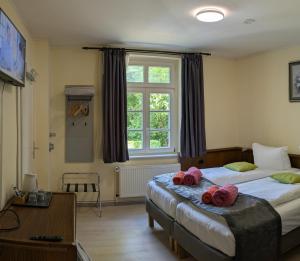 a bedroom with a bed with pink towels on it at Pension Celia in Wismar