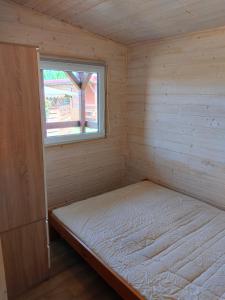 a bed in a room with a window at Pod starą chatą 2 in Wicie