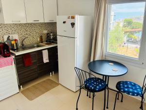 a kitchen with a small table and a refrigerator at Small House in Bodrum in Milas