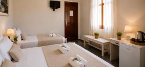 a hotel room with two beds and a television at Knossos Breeze in Sitia
