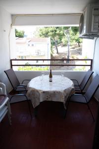 a table and chairs with a bottle of wine on it at Apartment Jasovic in Ulcinj