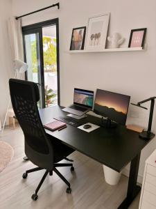 a desk with a computer and a laptop and a chair at Oasis in paradise with pool in La Oliva +17 photos