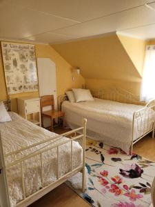 a bedroom with two beds and a table and a chair at Linnåsen stuga in Rottneros