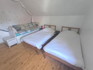 two beds in a room with a couch at Smiley in Blankenberge