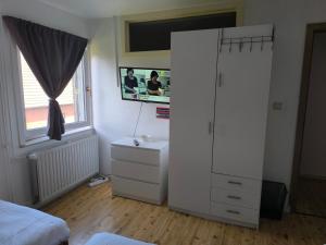 a bedroom with a white cabinet and a tv at Smiley in Blankenberge