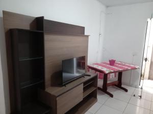 a living room with a table and a tv and a table at Ambiente familiar em Poços de caldas in Poços de Caldas