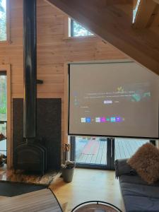 a large projection screen in a room with a couch at Nobelowka Forest SPA in Huta Podgórna