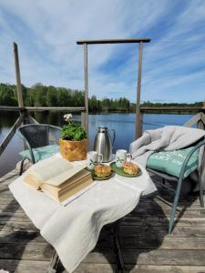 a table with a book and some food on a boat at Linnåsen stuga in Rottneros +29 photos