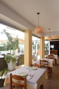 a restaurant with white tables and chairs and windows at Hawaii Accommodation Pelekas in Pelekas