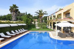a hotel with a swimming pool and chairs and a building at Hawaii Accommodation Pelekas in Pelekas