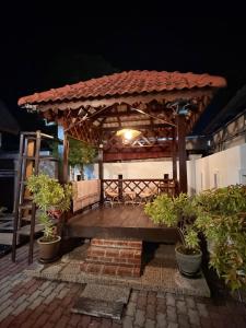 a wooden bench with a gazebo at night at NorvillaB Pantai Cenang in Pantai Cenang