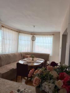 a living room with a couch and a table with flowers at Къща за гости Шишкови in Shabla