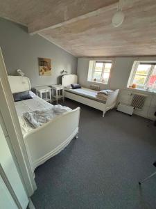 a bedroom with two beds and a couch and a table at Charlottenlunds Gårdshotell & Restaurang in Långaryd