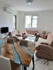 a living room with a wooden table and couches at Sea flavor 2 in Shëngjin