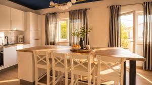 a kitchen with a wooden table and white chairs at Apartments Stina & Villa Ina in Seget Vranjica +26 photos