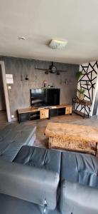 a living room with a wooden table and a couch at Le White Garden in De Panne