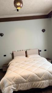 a bed in a bedroom with a white wall at Jessica's House in Luxor