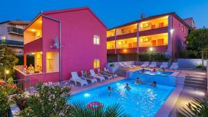 a group of people in the swimming pool of a house at Apartments Stina & Villa Ina in Seget Vranjica
