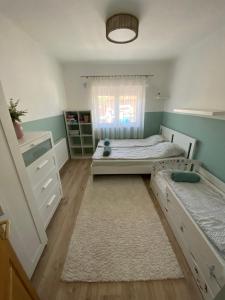 a small bedroom with two beds and a window at Deák Apartman Gárdony in Gárdony