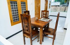 a wooden dining room table and chairs in a room at Villa Vianna in Nilaveli