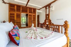 a bedroom with a bed with a white bedspread at Sandbox Apartment 4 Diani Beach Kenya in Ukunda