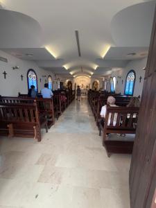 a church with wooden pews and people in the aisle at Beachfront Studio in Castillo de la Duquesa in Castillo de Sabinillas