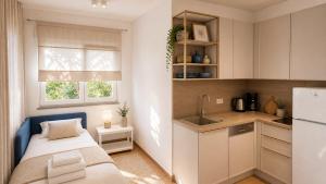 a small kitchen with a bed and a sink at Apartments Stina & Villa Ina in Seget Vranjica