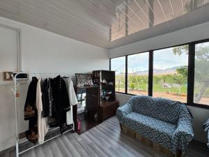 a room with a couch and a chair and windows at Guesthouse Snow Leopard - 'Ak Ilbirs' in Tong