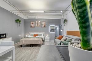 a living room with a bed and a couch at Flow Urban Living by DiffeRent in Ferrara